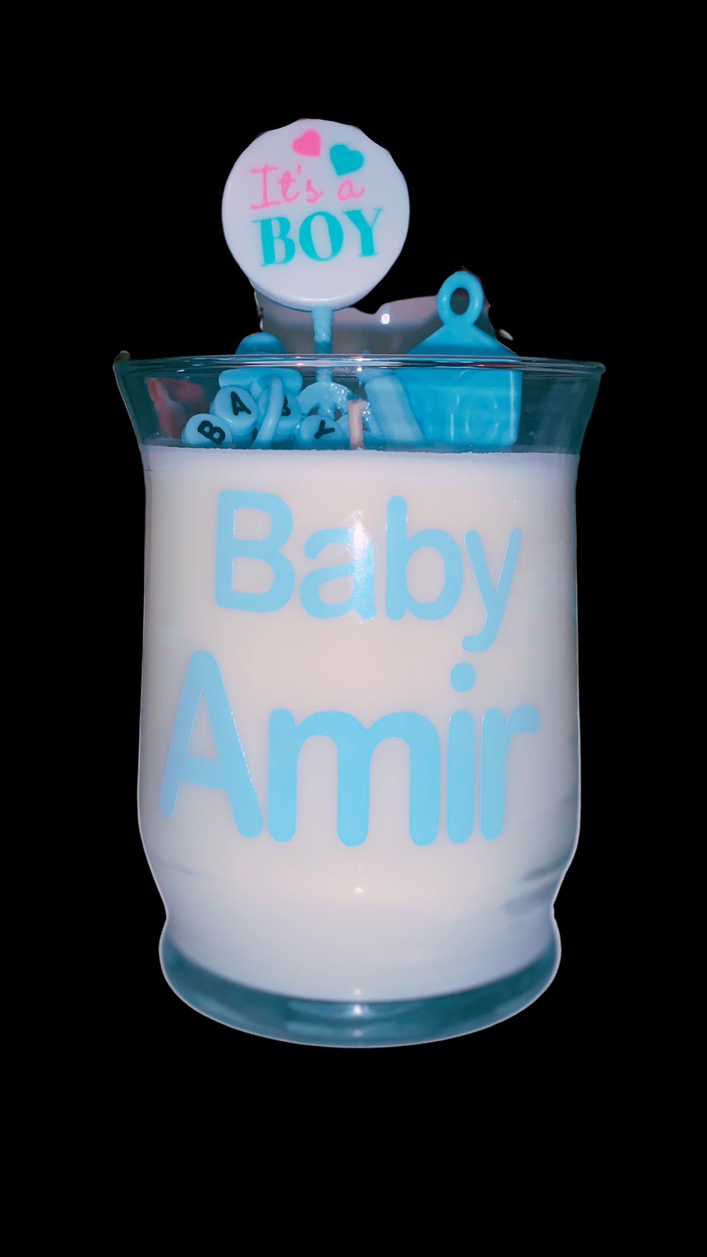 Blue 10oz baby shower candle with 'Baby Boy' topper, wax baby feet, rubber duck, and baby-themed decorations (decorations may vary on availability). Includes an instruction card and customizable label for baby's name. Scent: Baby Powder